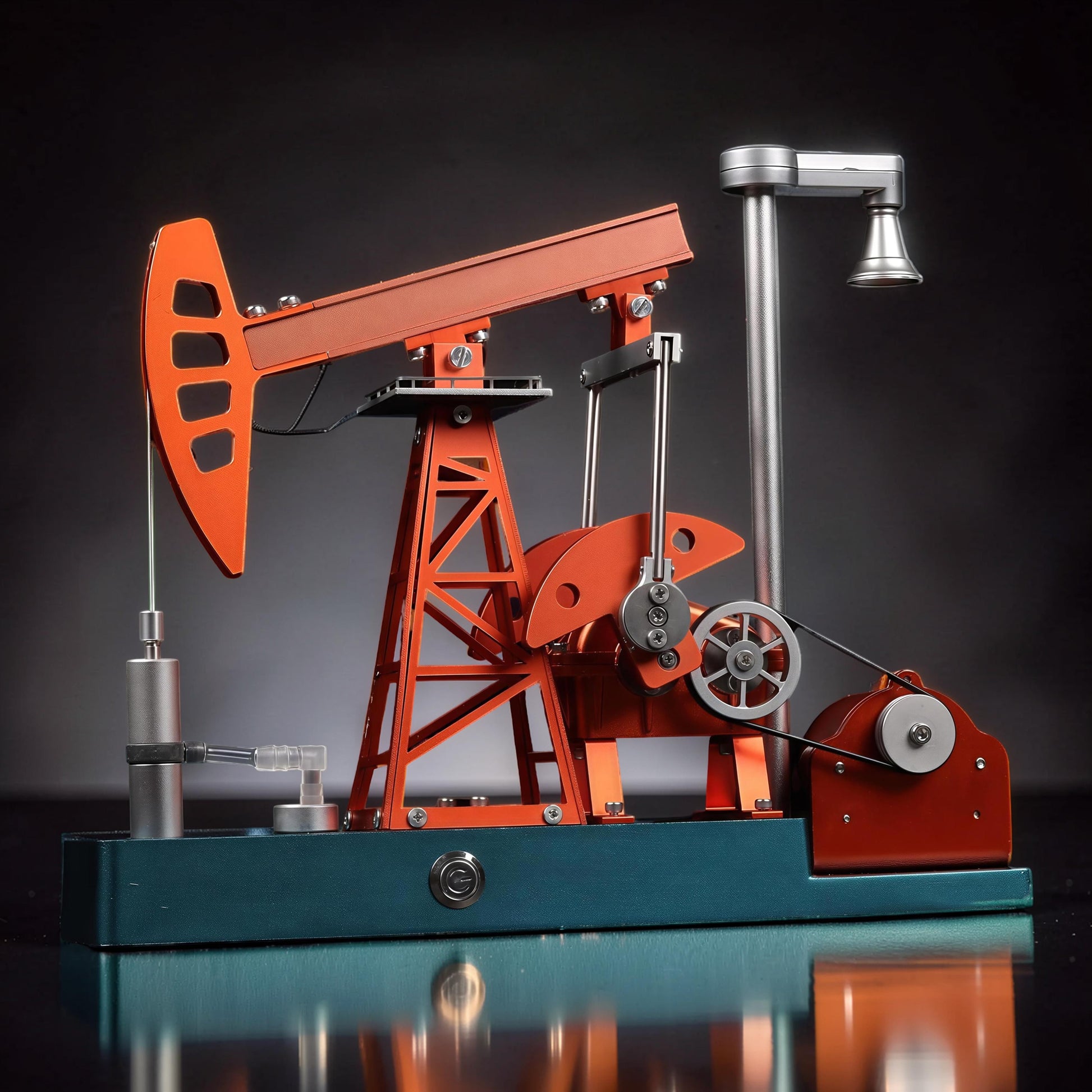 The Curious Mind Oil Derrick Pumping Unit DIY Kit, a detailed metal model with orange and teal accents, featuring intricate mechanical parts and a working pump.