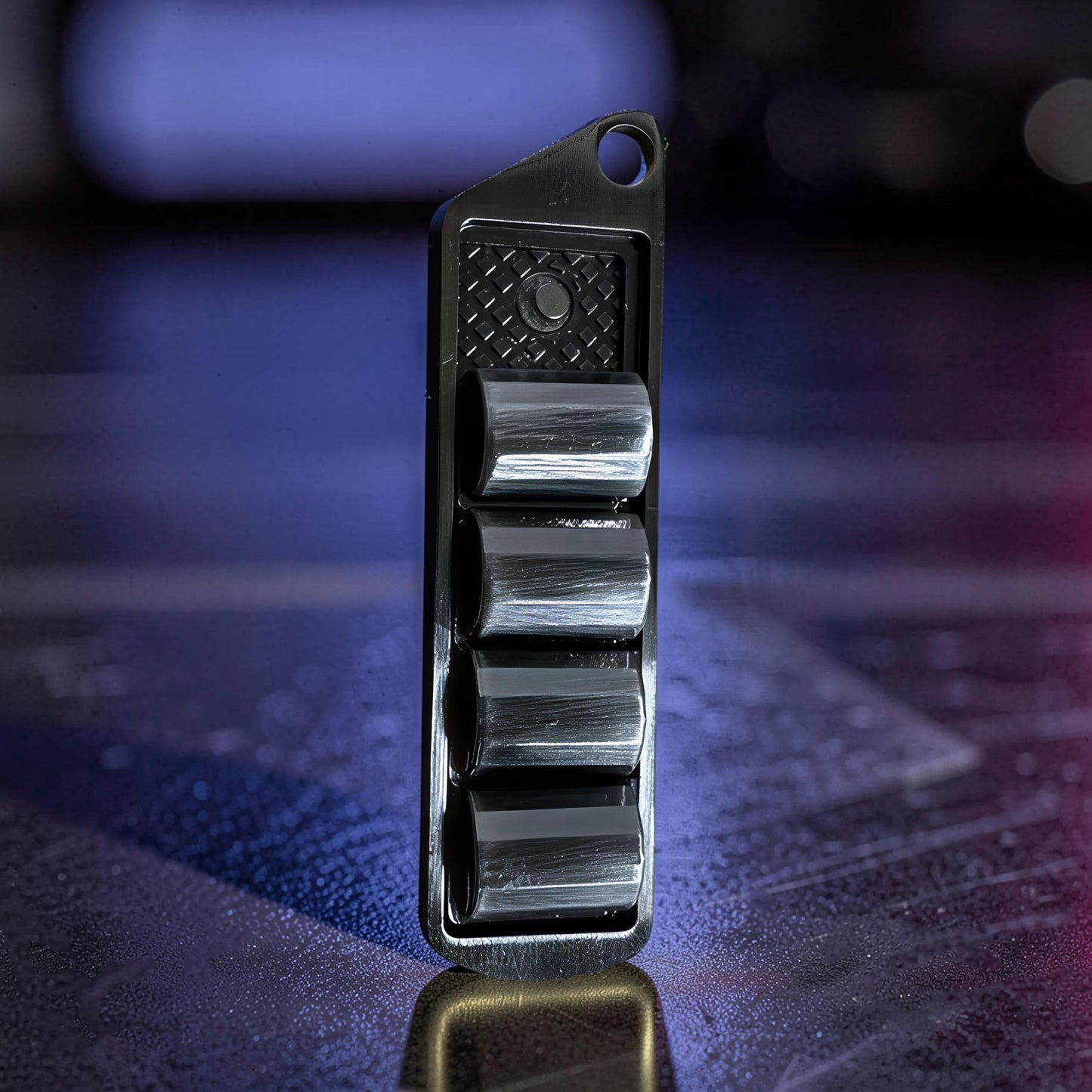 The Curious Mind Pea Pod Pop Coin Clicker, a novelty metal fidget toy with four black pods that click when pressed.
