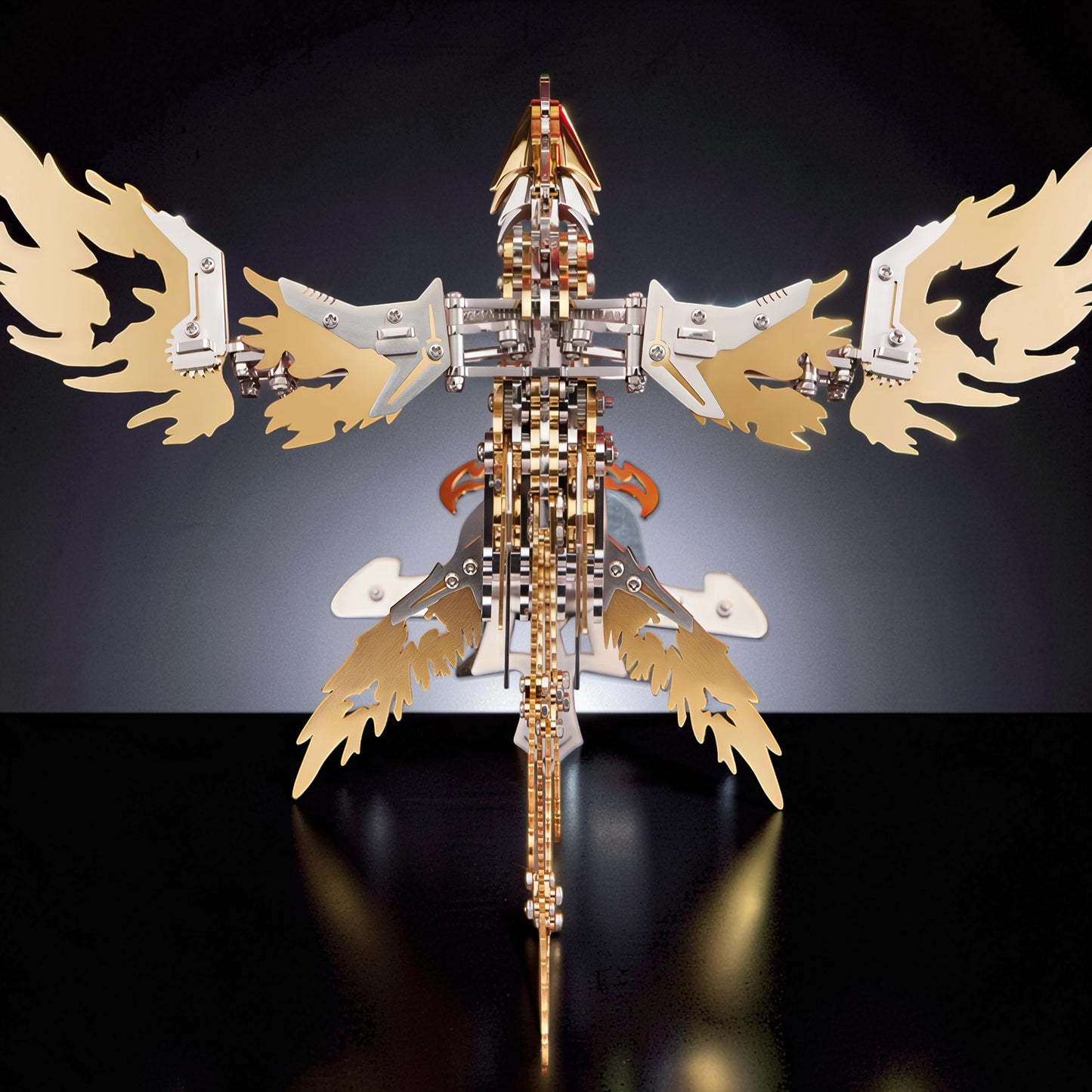 The Curious Mind Phoenix DIY Kit, a mechanical model with silver and gold metal parts, featuring intricate wings and tail.