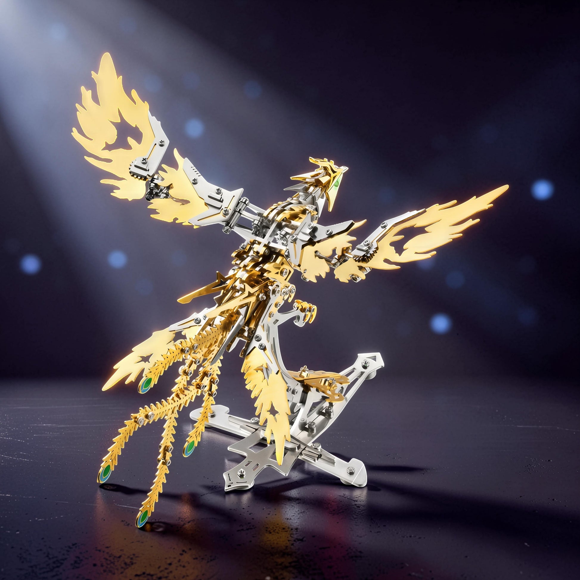 The Curious Mind Phoenix DIY Kit, a metallic mechanical bird model in silver and gold with green accents, displayed on a stand.