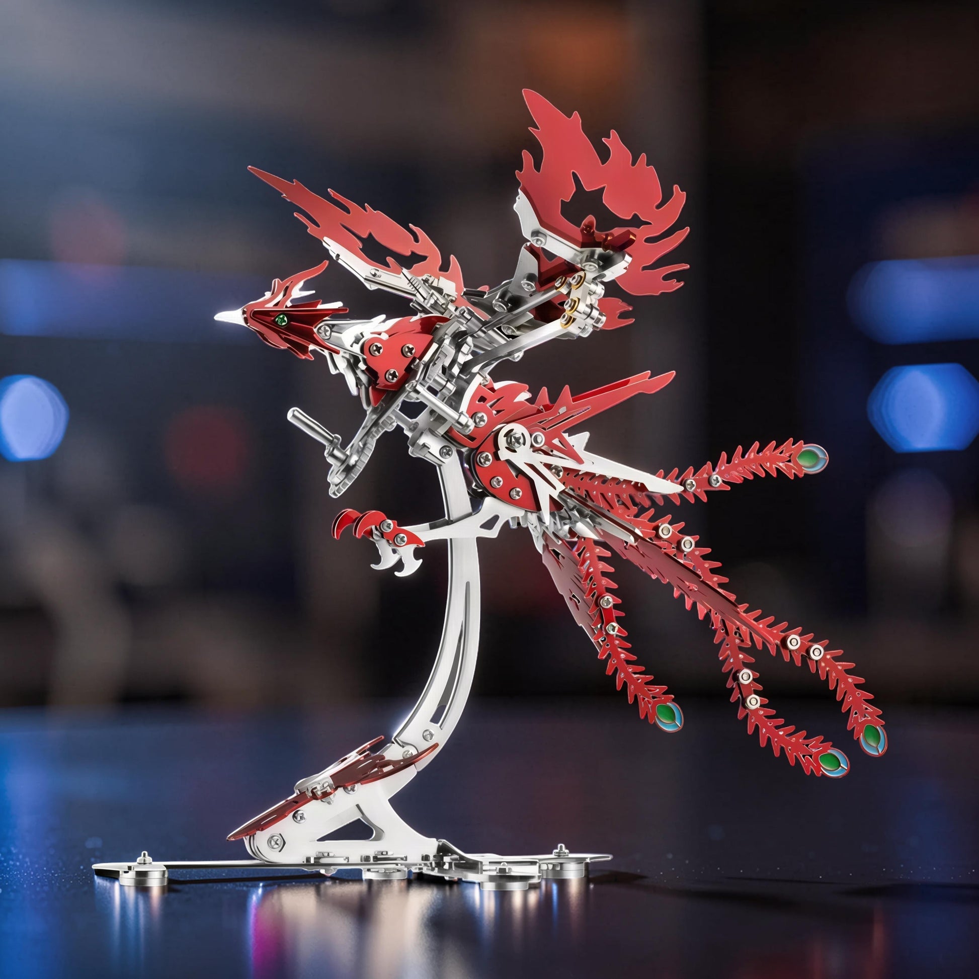 The Curious Mind Phoenix DIY Kit: intricate silver and red metal mechanical bird model with detailed wings and tail, displayed on a stand.