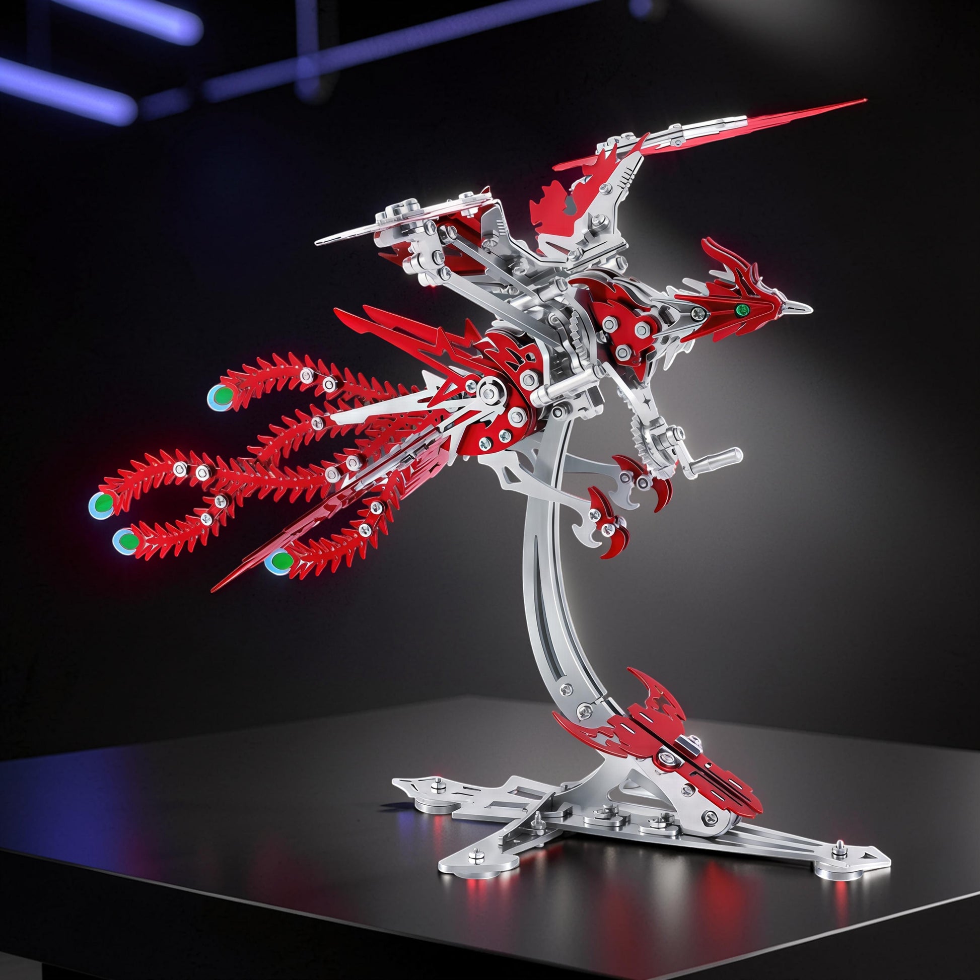 The Curious Mind Phoenix DIY Kit, a silver and red metal mechanical creature model with green glowing accents, displayed on a stand.