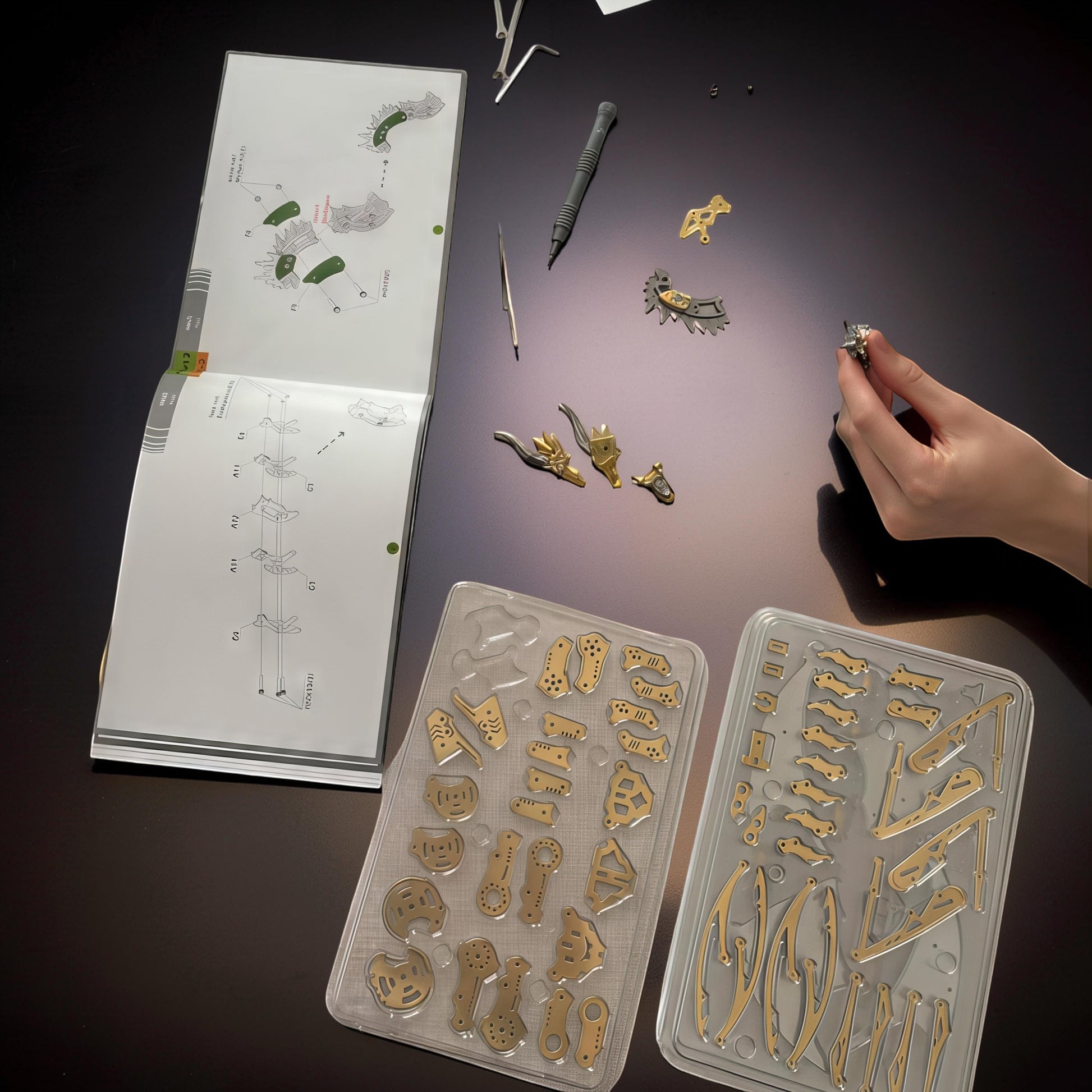 The Curious Mind Pterosaur DIY Kit with metal parts laid out next to instructions and tools. A hand holds a small assembled piece.