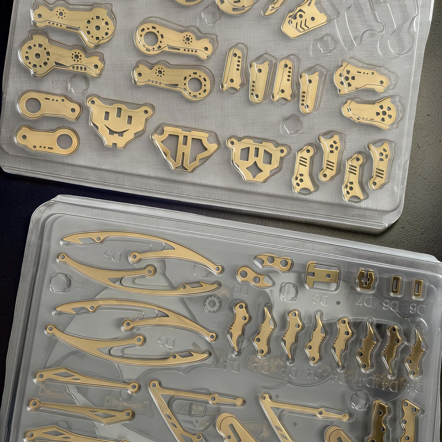 The Curious Mind Pterosaur DIY Kit metal parts laid out in plastic trays, ready for assembly.