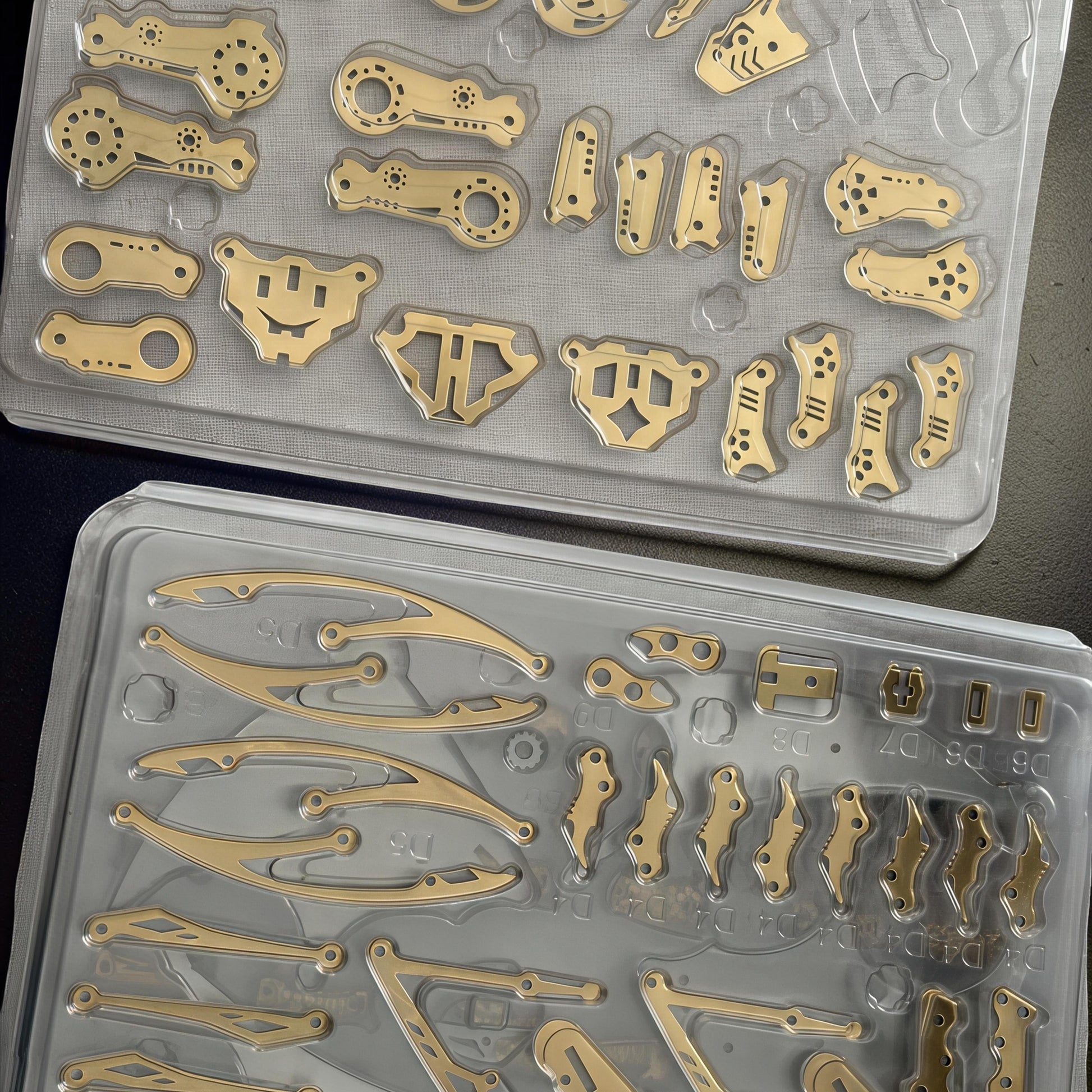 The Curious Mind Pterosaur DIY Kit metal parts laid out in plastic trays, ready for assembly.