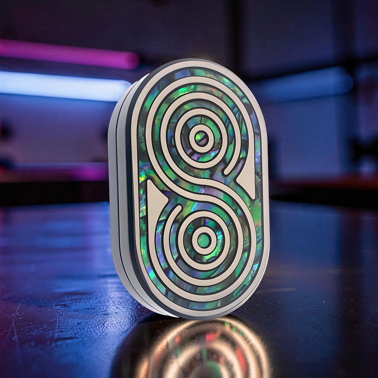 The Curious Mind Fritillary Push Slider fidget toy with abalone inlay and silver accents.