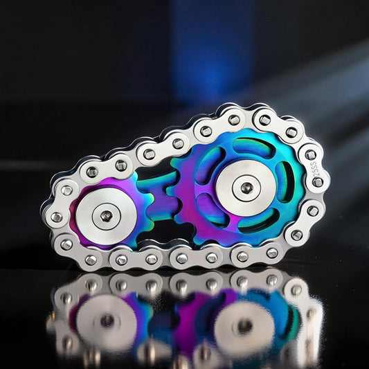 The Curious Mind Gear Chain Sprocket Spinner, a metal fidget toy with rainbow iridescent gears and a silver chain.