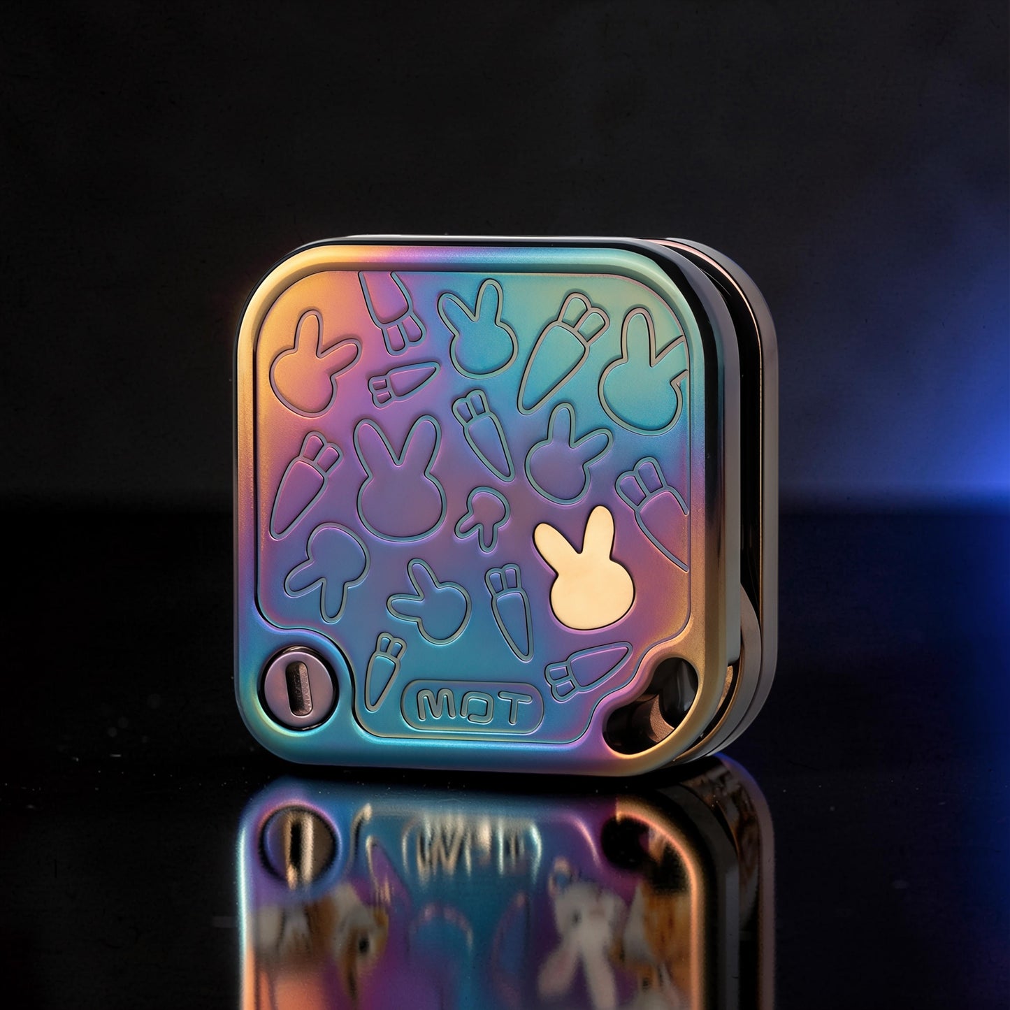 The Curious Mind Rabbit Tuning Fork Clicker fidget toy with a rainbow iridescent metal finish and embossed bunny and carrot designs.