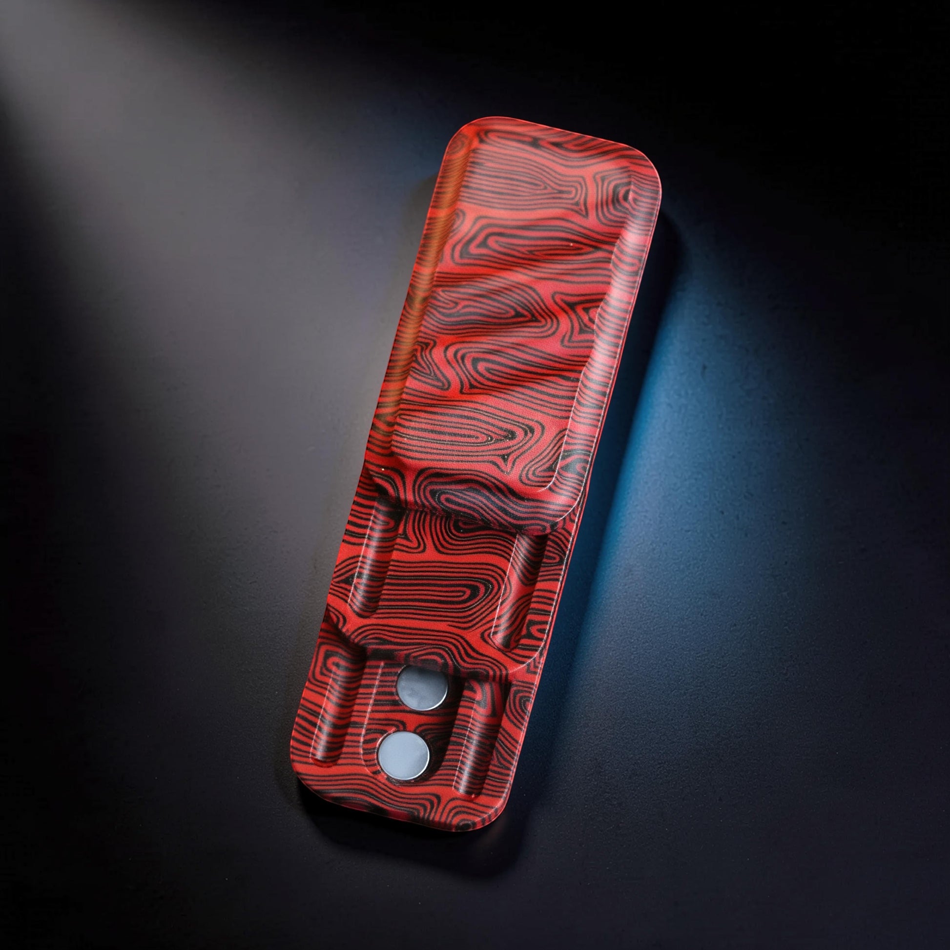 The Curious Mind Three-Layer Push Card Slider fidget toy with red and black swirling pattern. Compact fiberglass design.