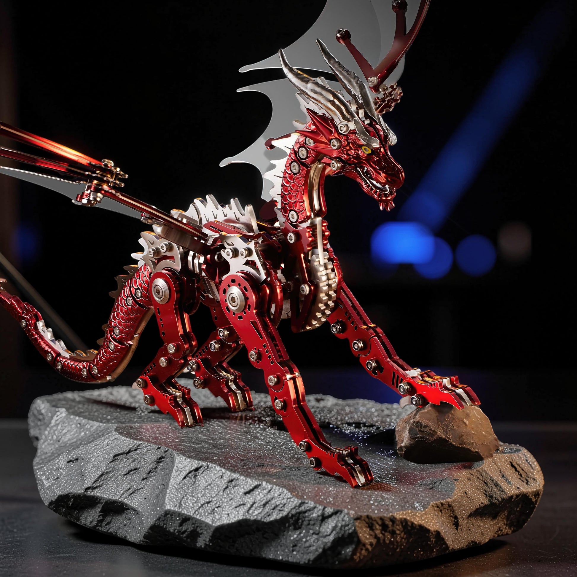 The Curious Mind Pterosaur mechanical model kit, a red and silver metal dragon with articulated wings on a rock base.