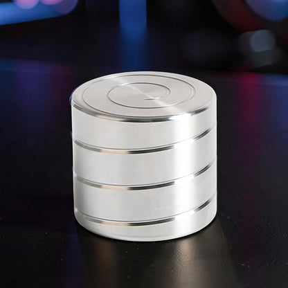 The Curious Mind Vortecon kinetic desk spinner is a silver metal cylinder with a spiral design on top, perfect for stress relief and focus.