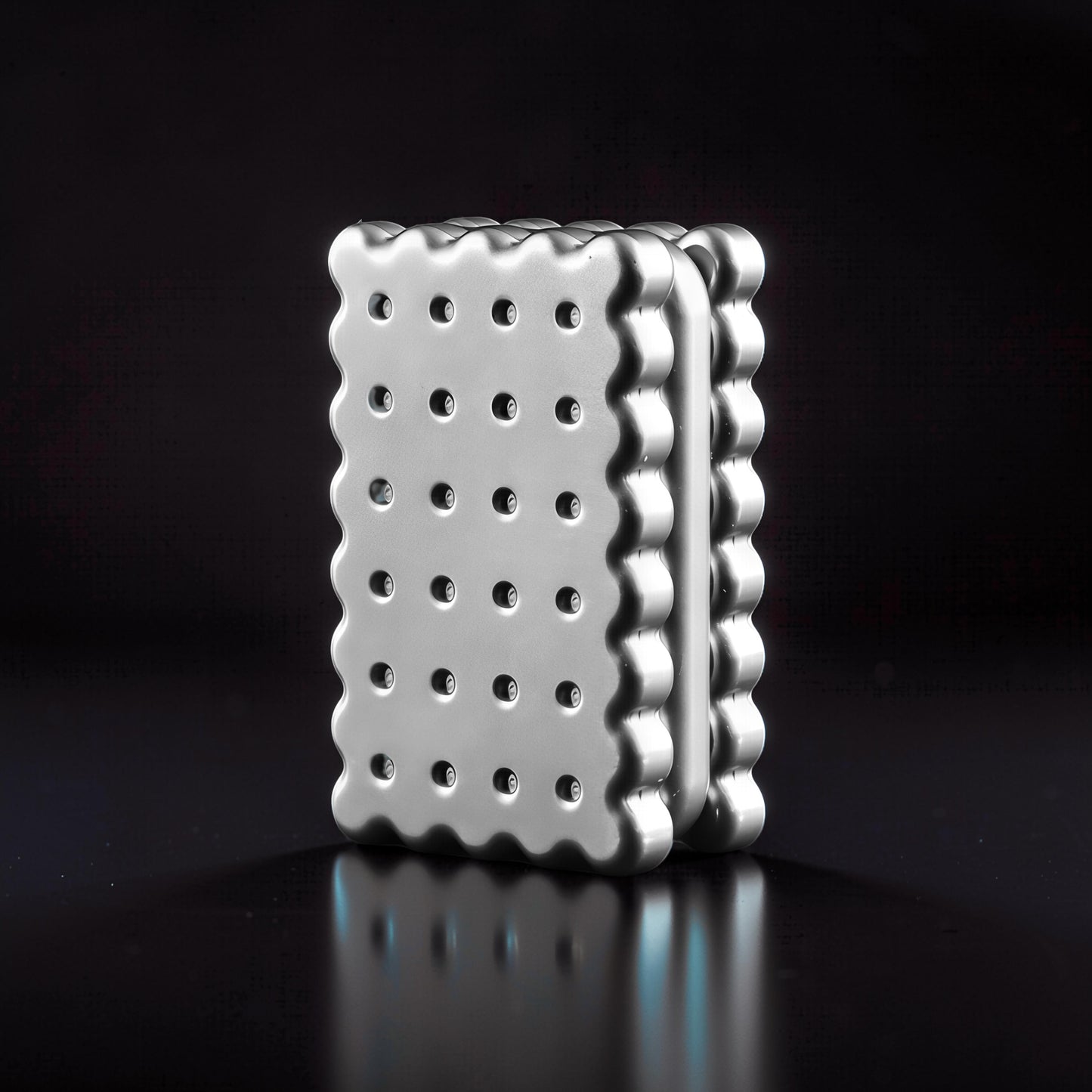 The Curious Mind Biscuit Push Card Slider, a silver metal fidget toy with a scalloped edge and perforated surface.