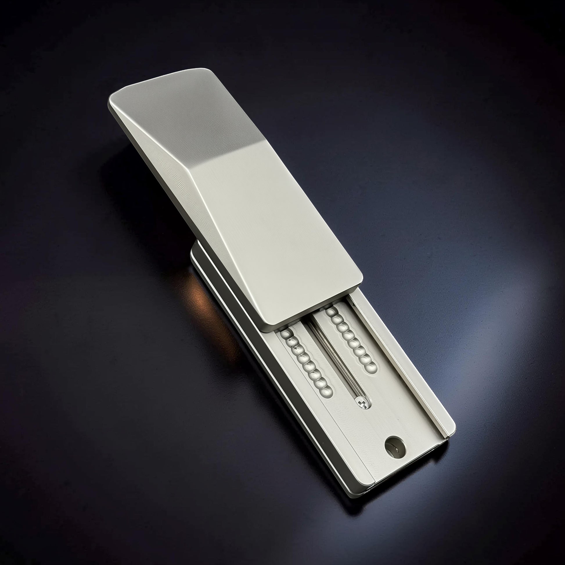The Curious Mind Cyberpunk Truck Push Slider, a compact silver metal fidget toy with a satisfying push-and-return motion.