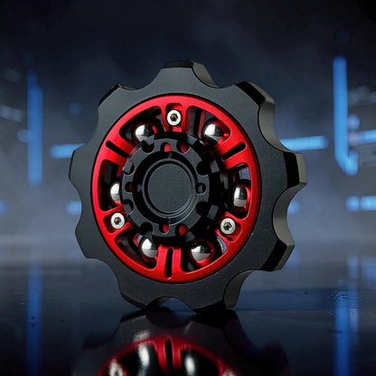The Curious Mind Six-Bead Gear Spinner in black and red metal with silver bearings, designed like a gear for fidgeting and display.