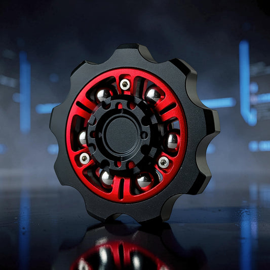 The Curious Mind Six-Bead Gear Spinner in black and red metal with silver bearings, designed like a gear for fidgeting and display.