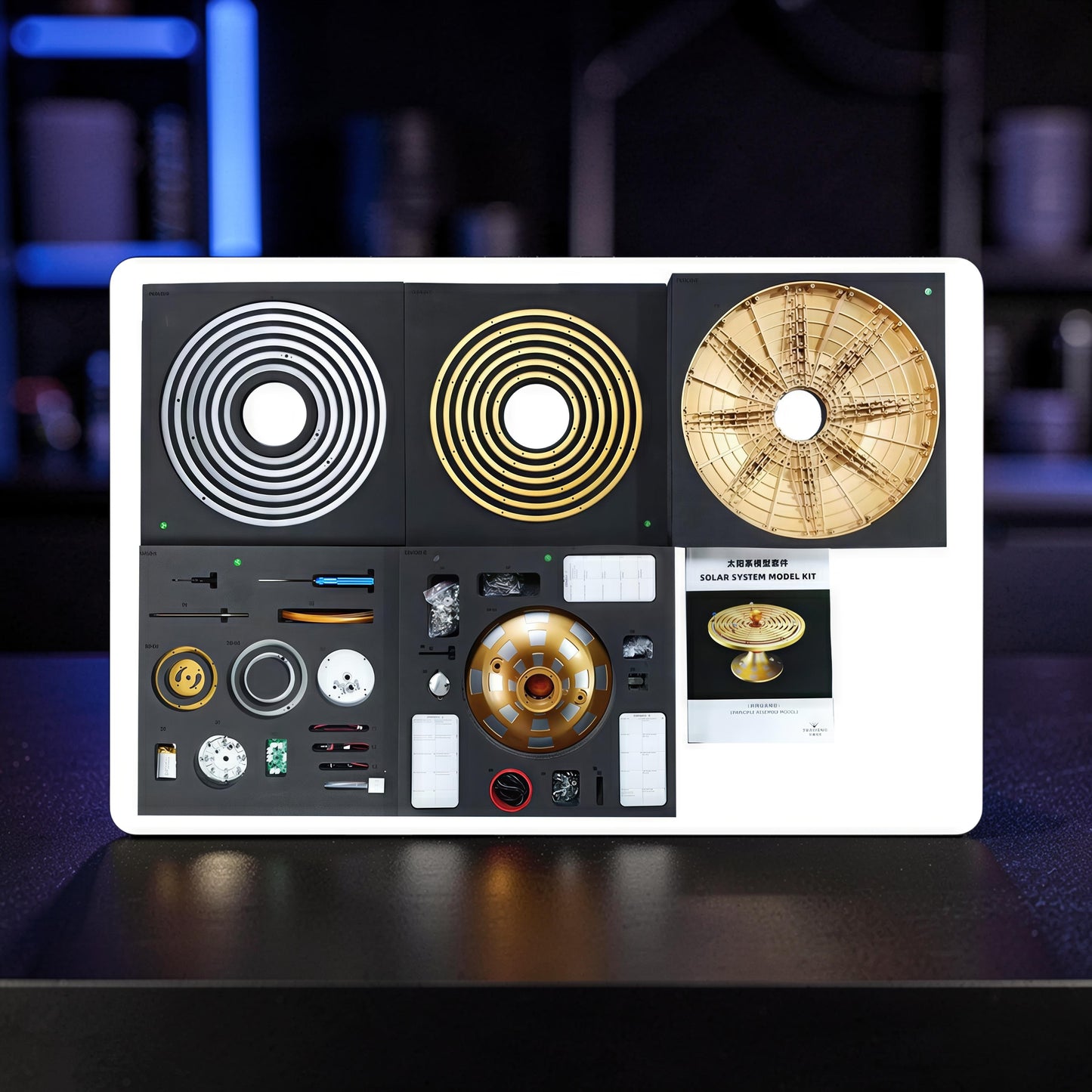 The Curious Mind Solar System DIY Kit with metal components, including concentric rings and a central gear mechanism, for STEM education.