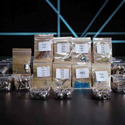 The Curious Mind Spider DIY Kit - Style B, metal mechanical creature model kit components organized in labeled bags and containers.