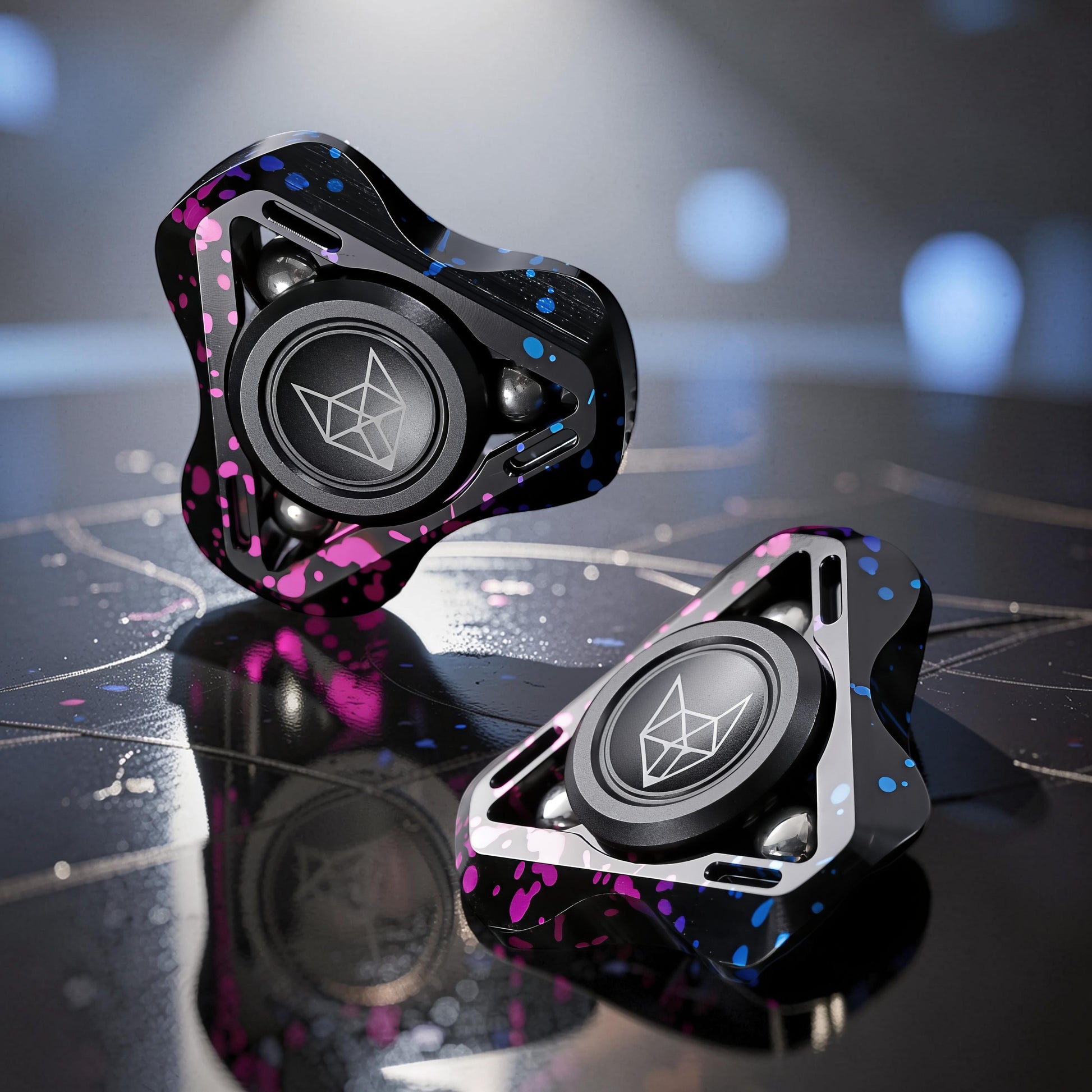 The Curious Mind Spirit Fox Glow Spinner: black metal fidget spinner with pink and blue splatter design, featuring a central fox logo.