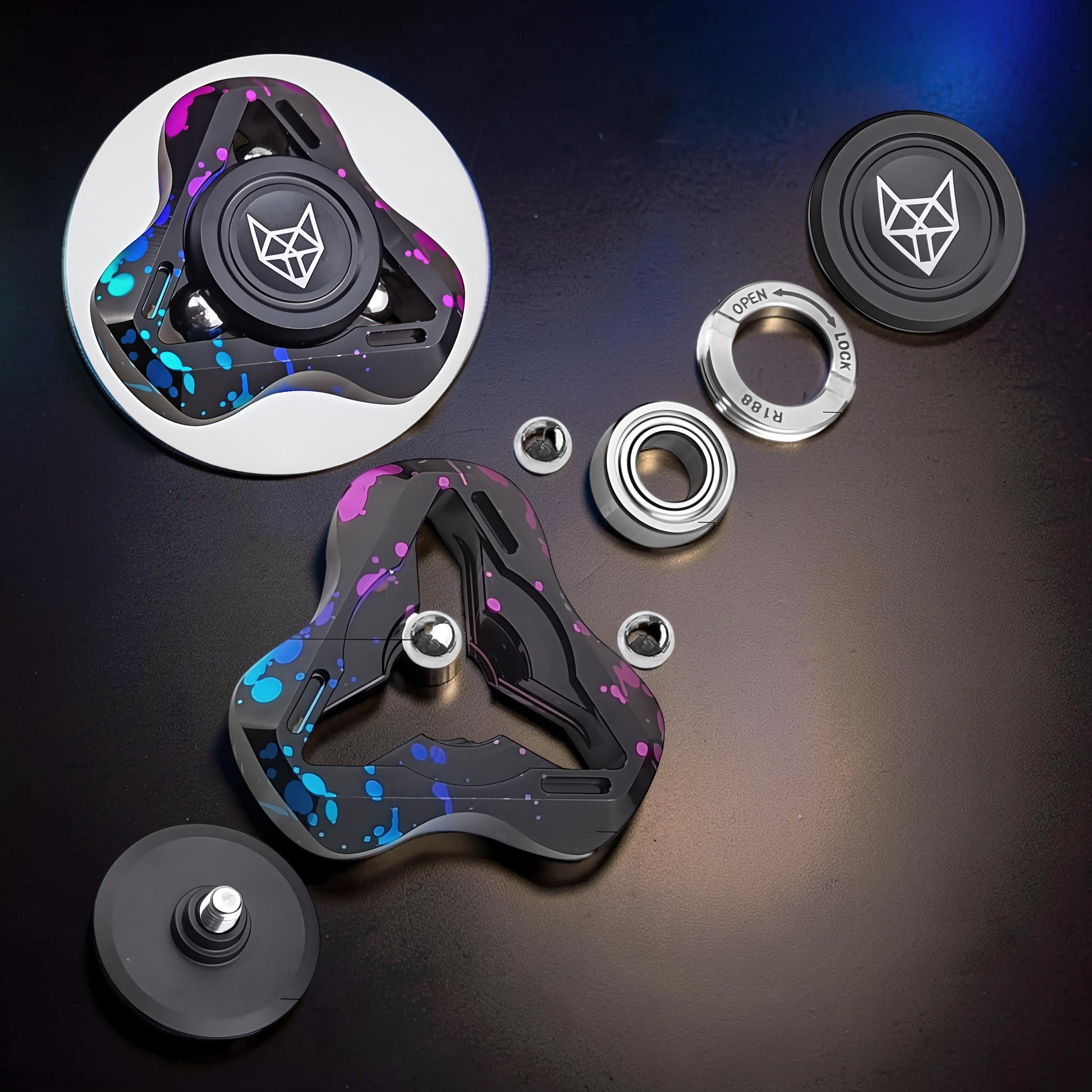 The Curious Mind Spirit Fox Glow Spinner with black, blue, and pink splatter design. Metal construction with R188 bearing.