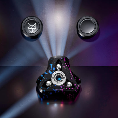 The Curious Mind Spirit Fox Glow Spinner with black, blue, and pink splatter design. Features metal construction and light-up detailing.