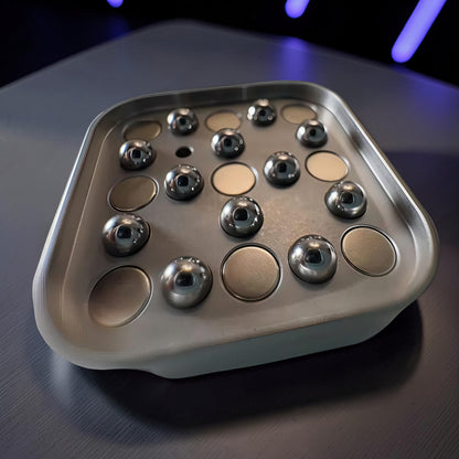 The Curious Mind Tetris Stainless Steel Slider fidget toy with magnetic balls and circular indentations.