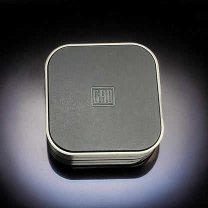 The Curious Mind Tetris Stainless Steel Slider fidget toy with a dark grey textured top and silver trim.