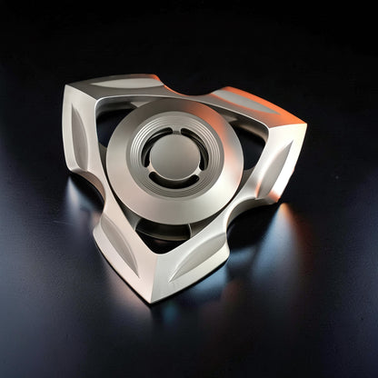 The Curious Mind stainless steel tri-blade spinner with a futuristic, angular design. Metallic silver finish.