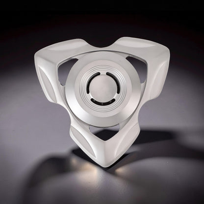 The Curious Mind stainless steel tri-blade spinner with a sleek, futuristic design and a central bearing.