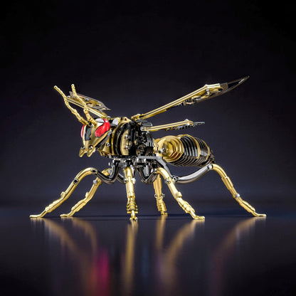 The Curious Mind Stainless Wasp 3D metal model kit, gold and silver finish, intricate mechanical design with red eyes.