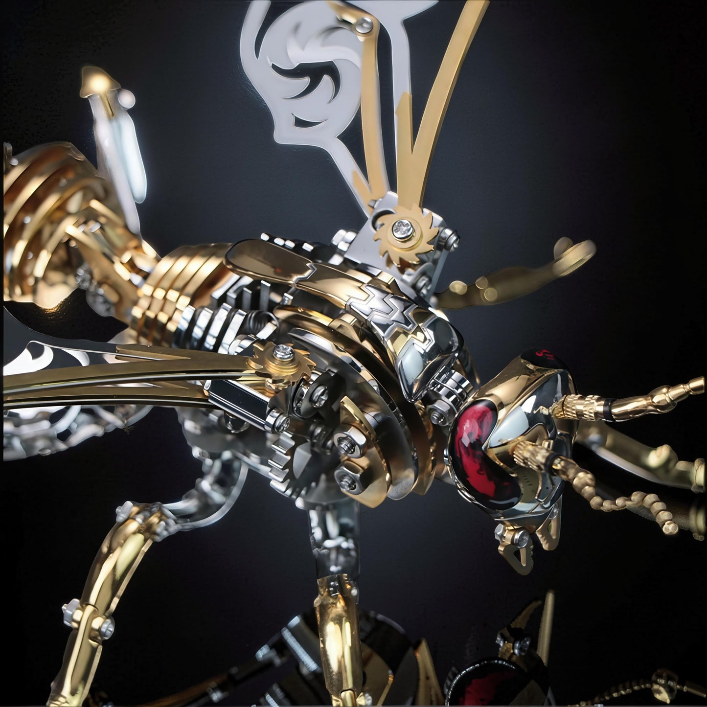 The Curious Mind Stainless Wasp 3D metal model kit in gold and silver with intricate mechanical details and red eyes.