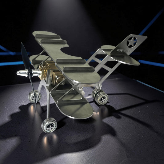 The Curious Mind Stirling Engine Model Aircraft, a metal biplane with a propeller and wheels, designed for desktop display and engineering enthusiasts.