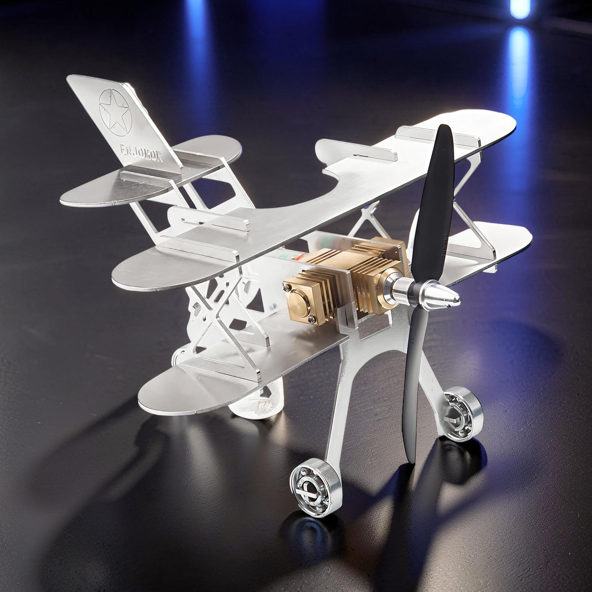 The Curious Mind Stirling Engine Model Aircraft, a silver metal biplane with a gold engine and black propeller, on display.