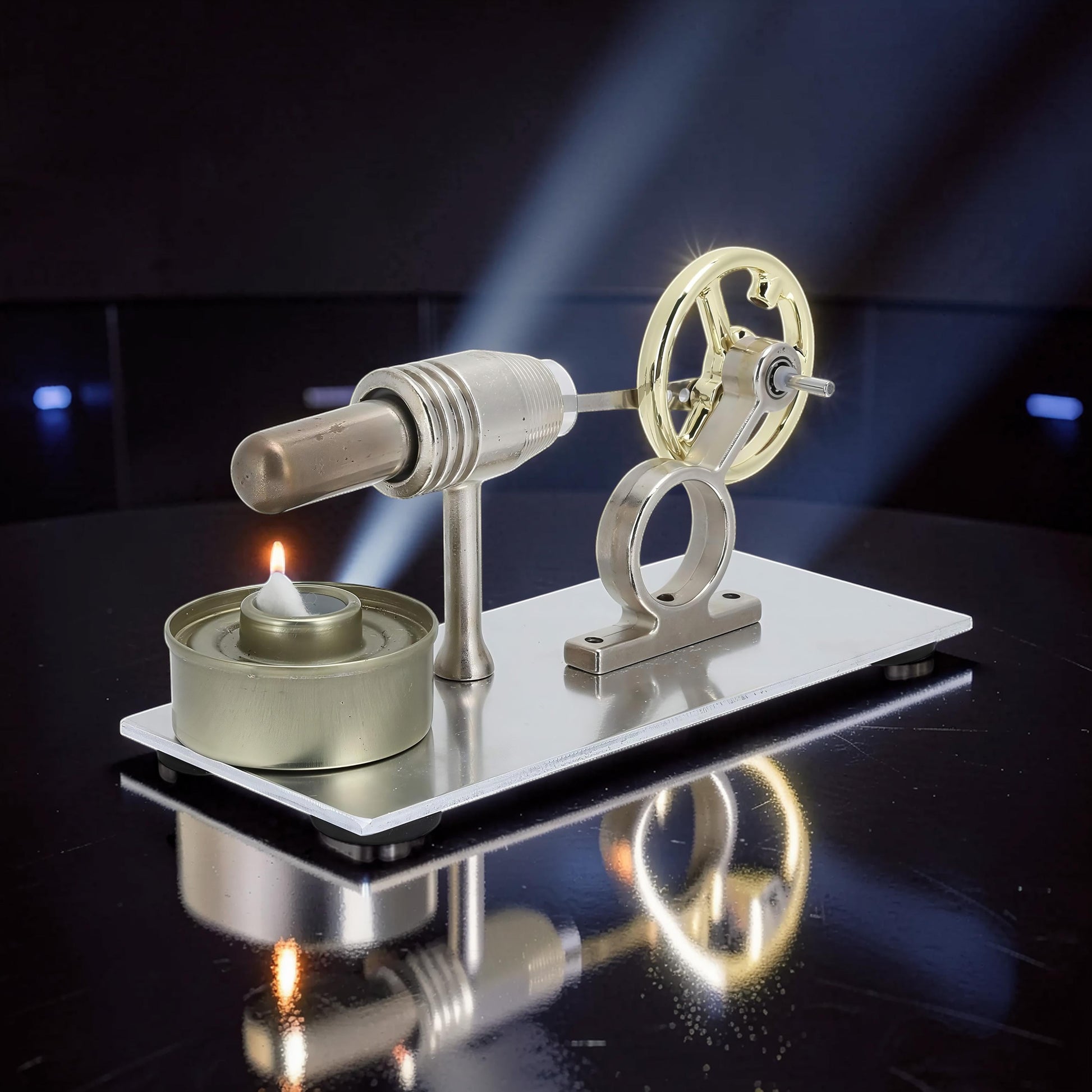 The Curious Mind Classic Stirling Engine Display, a running mechanical model with a gold flywheel and silver metal components, powered by a candle.