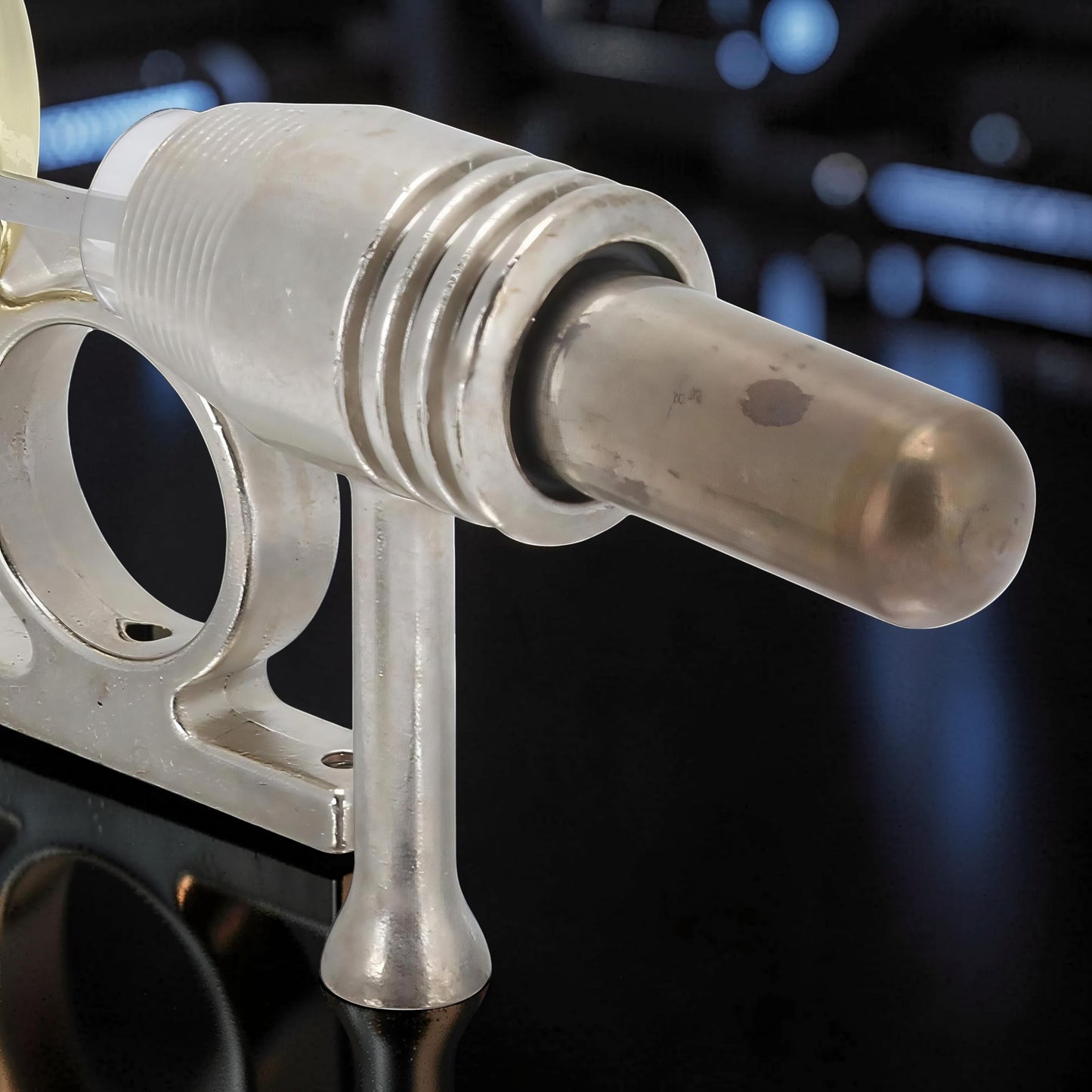 The Curious Mind Classic Stirling Engine Display mechanical model, made of polished metal with a clear cylinder and ribbed housing.