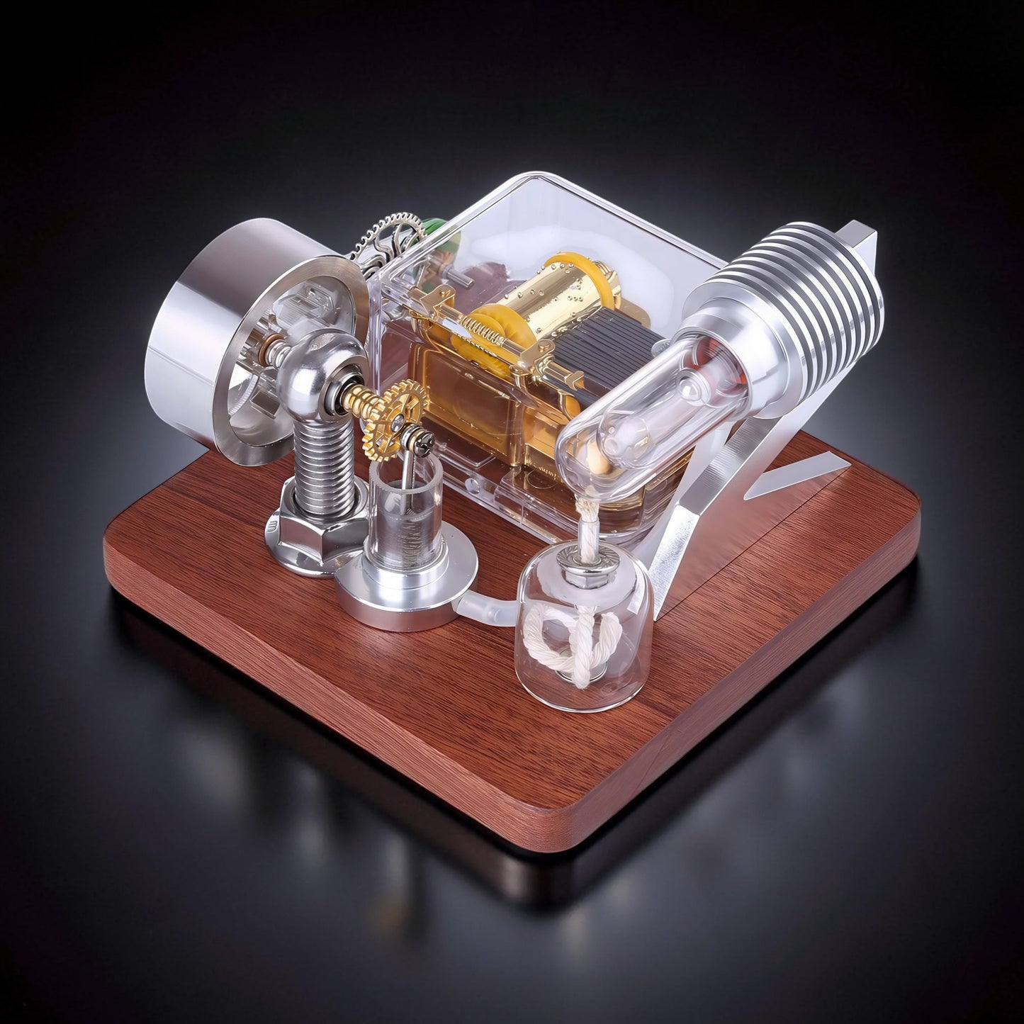 The Curious Mind Stirling Engine Music Box, a metal, wood, and quartz glass mechanical model with visible gears and a clear casing.