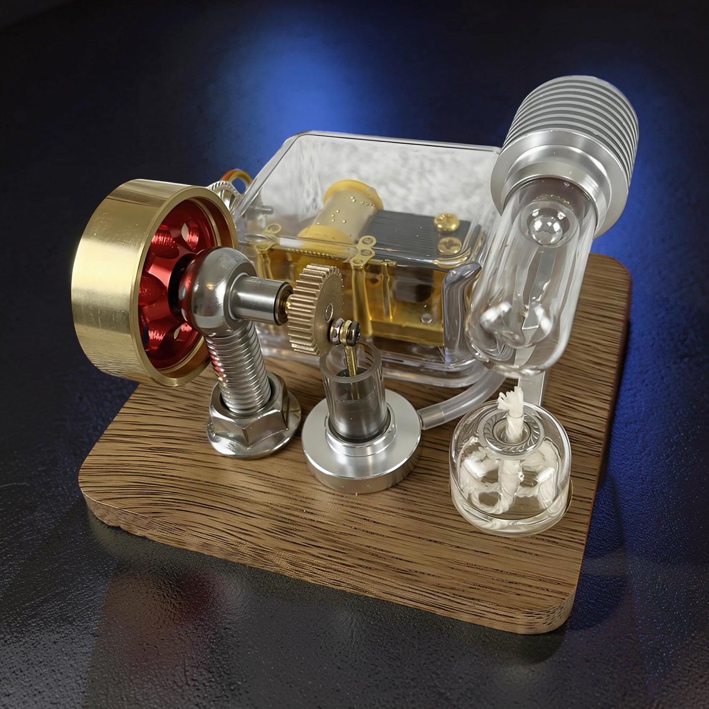 The Curious Mind Stirling Engine Music Box, a mechanical model with metal, wood, and quartz glass construction, featuring visible gears and a brass flywheel.