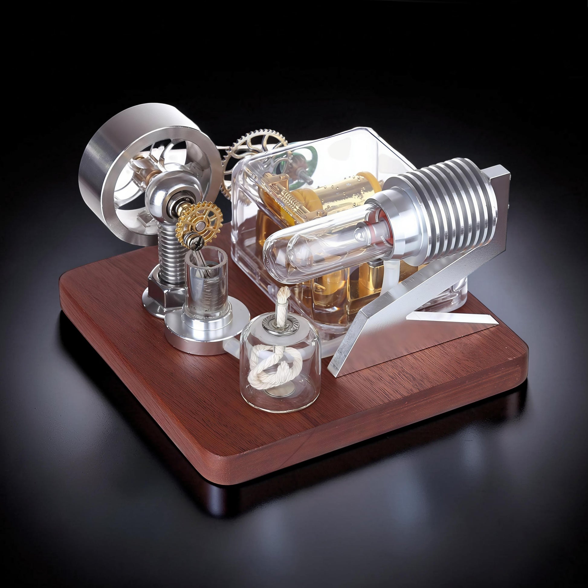 The Curious Mind Stirling Engine Music Box, a mechanical model with metal, wood, and quartz glass components, featuring a flywheel, gears, and a visible engine cylinder.