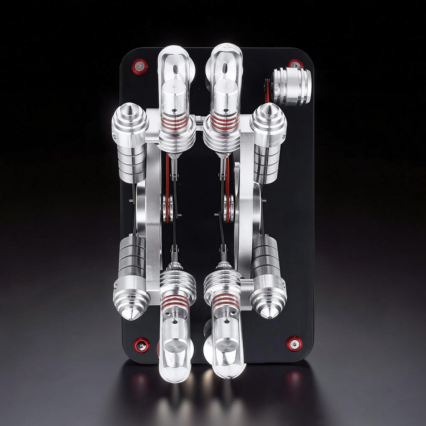 The Curious Mind Stirling Engine V4 Display Model, a metal mechanical model with red accents and visible pistons, on a black base.