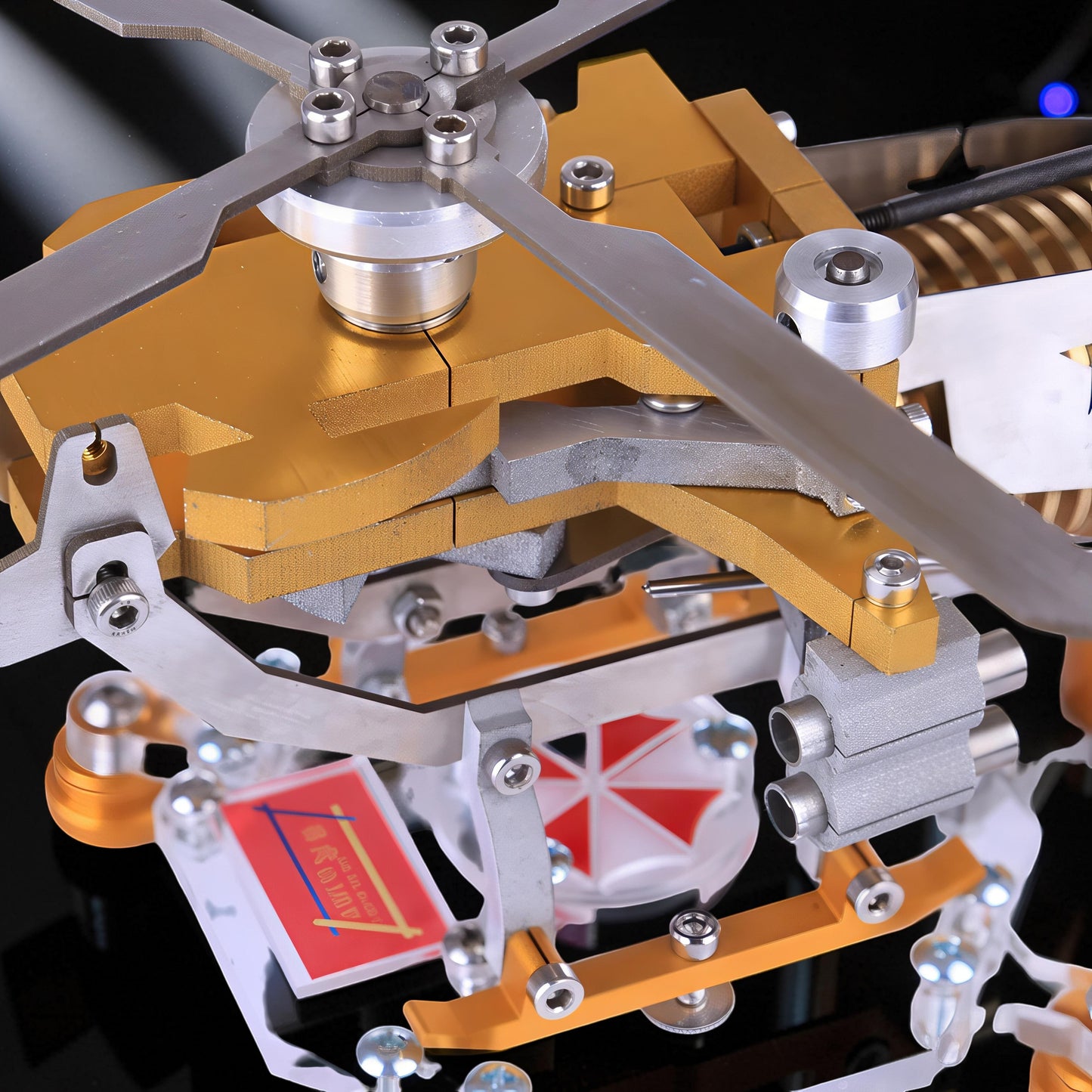 The Curious Mind Fire-Absorbing Stirling Helicopter Model features metal construction with gold and silver accents, intricate moving parts, and a detailed rotor.