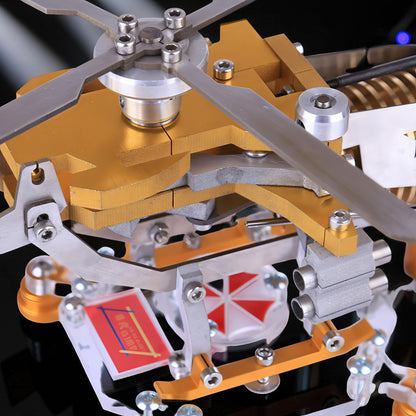 The Curious Mind Fire-Absorbing Stirling Helicopter Model features metal construction with gold and silver accents, intricate moving parts, and a detailed rotor.