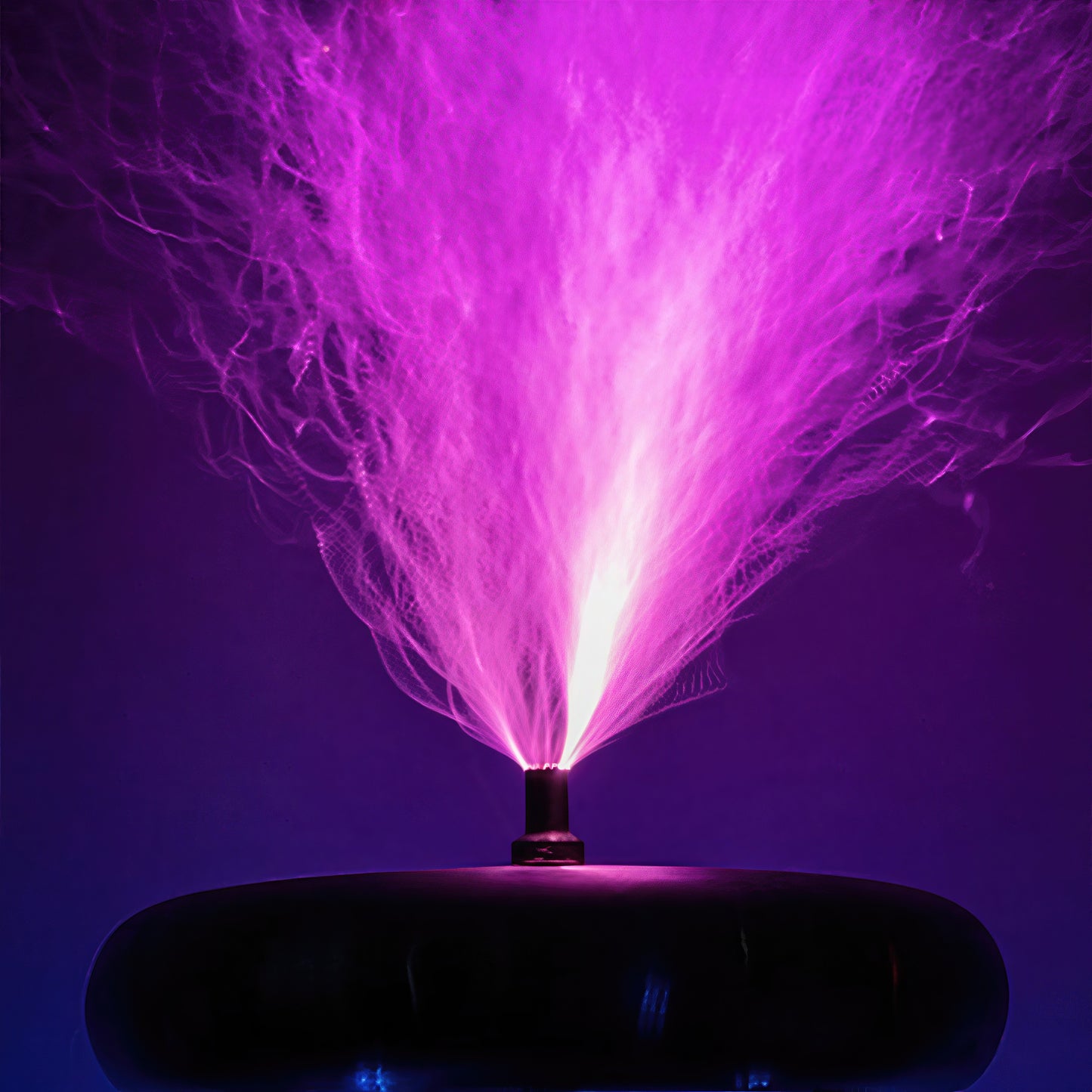The Curious Mind Tesla Coil TC20 Plasma Science Lamp with vibrant purple plasma streams emanating from the central electrode.