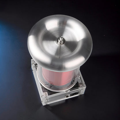 The Curious Mind Tesla Coil TC20 Plasma Science Lamp with brushed metal top and pink cylinder, on a black surface.