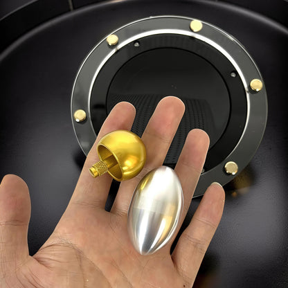 The Curious Mind Tesla Columbus Eggs Experiment Set features a gold spinning top and a silver egg on a hand, with a black and metallic display base.