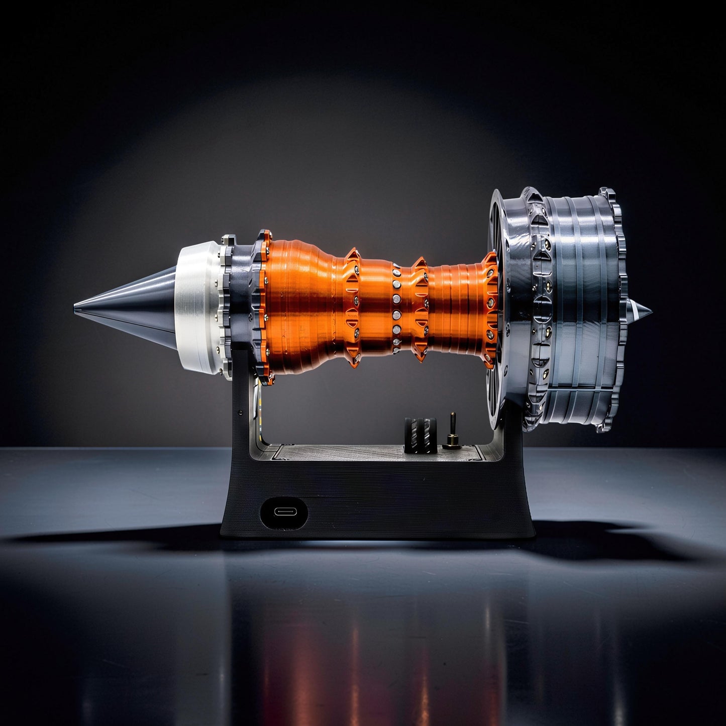 The Curious Mind TR900 Turbofan Engine DIY Kit, a detailed PLA model with orange and silver components on a black stand.