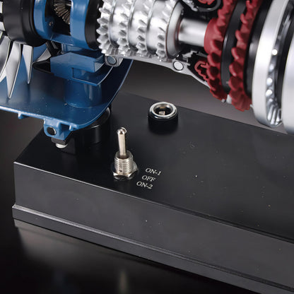 The Curious Mind Mini Turbofan Engine DIY Kit model with blue casing, silver gears, and red turbine blades on a black display base with toggle switch.