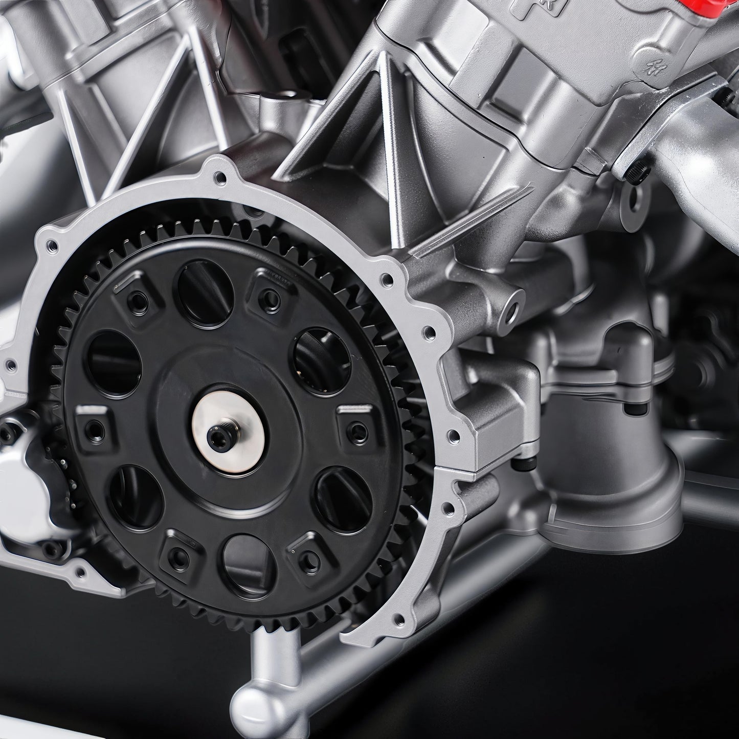 The Curious Mind V12 car engine DIY kit, a detailed metal mechanical model with a black gear and silver casing.