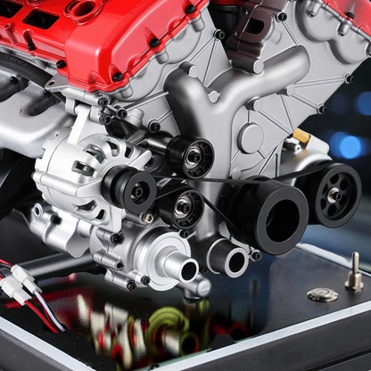 The Curious Mind V12 car engine DIY kit, a detailed metal mechanical model with red and silver components, featuring belts and pulleys.