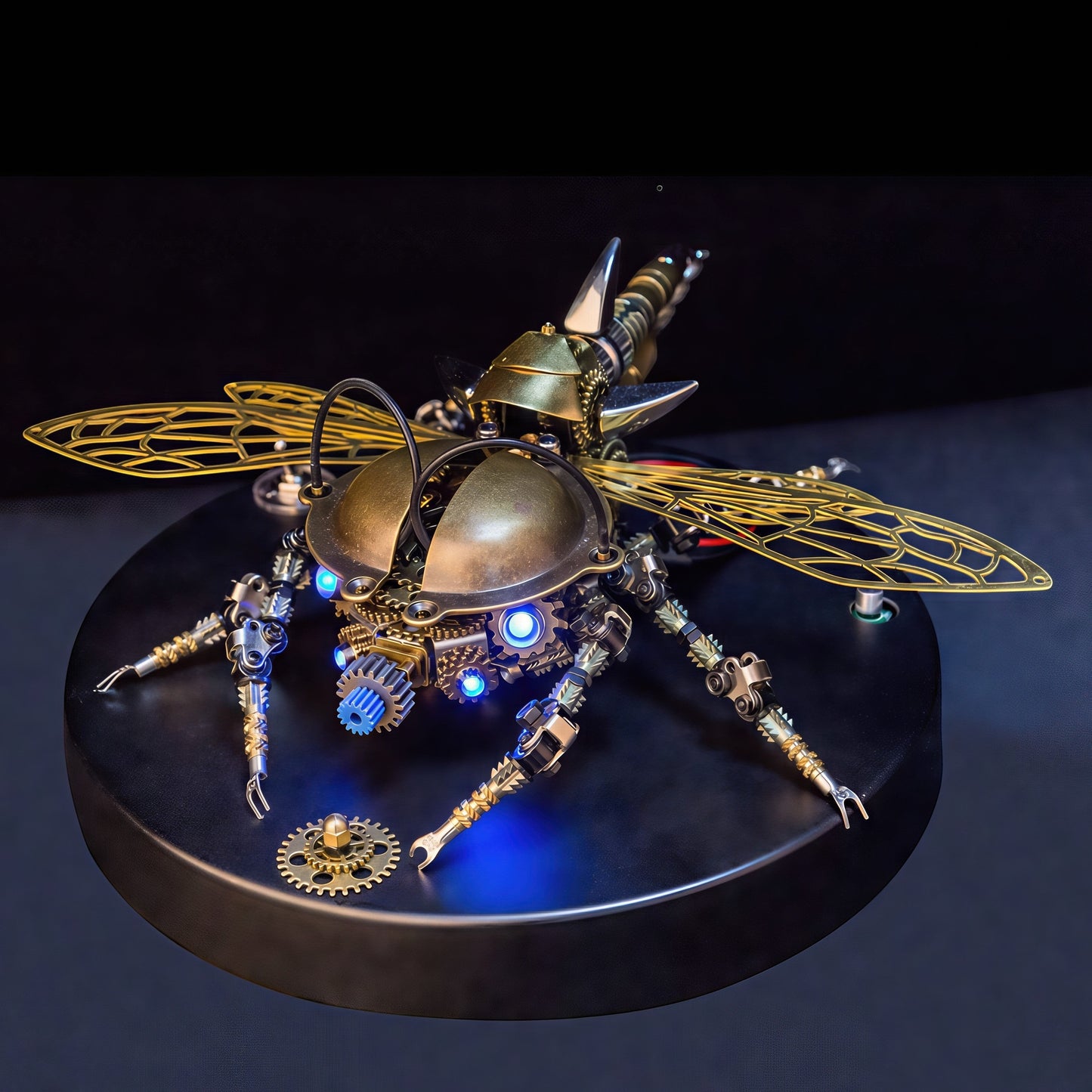 The Curious Mind War Beetle 3D metal model kit with intricate gears, brass body, and illuminated blue lights. Features delicate, golden wings and a steampunk aesthetic.