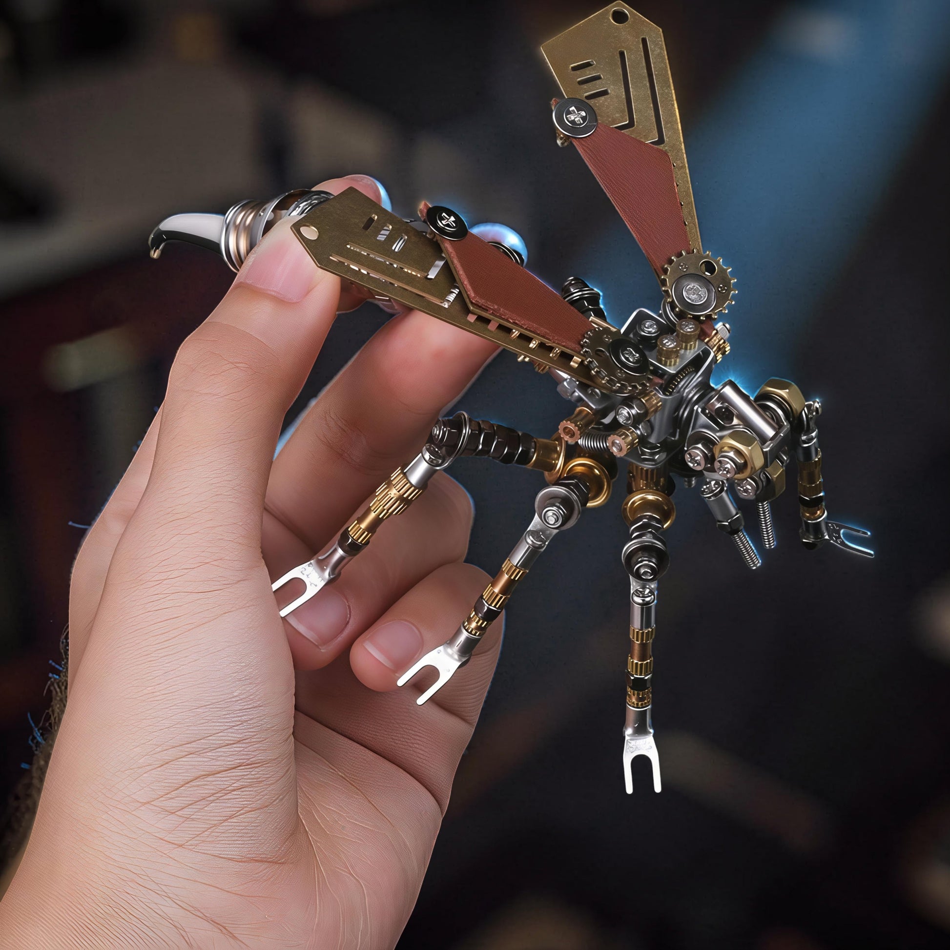 The Curious Mind Wasp premium 3D metal model kit, a detailed steampunk insect with intricate gears and metallic finish, held in a hand.