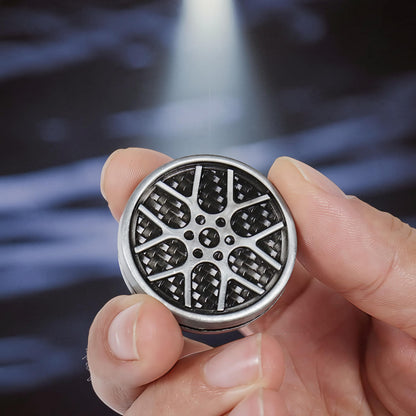 The Curious Mind Wheel Hub Coin Clicker fidget toy with a metal alloy rim and carbon fiber pattern wheel design.